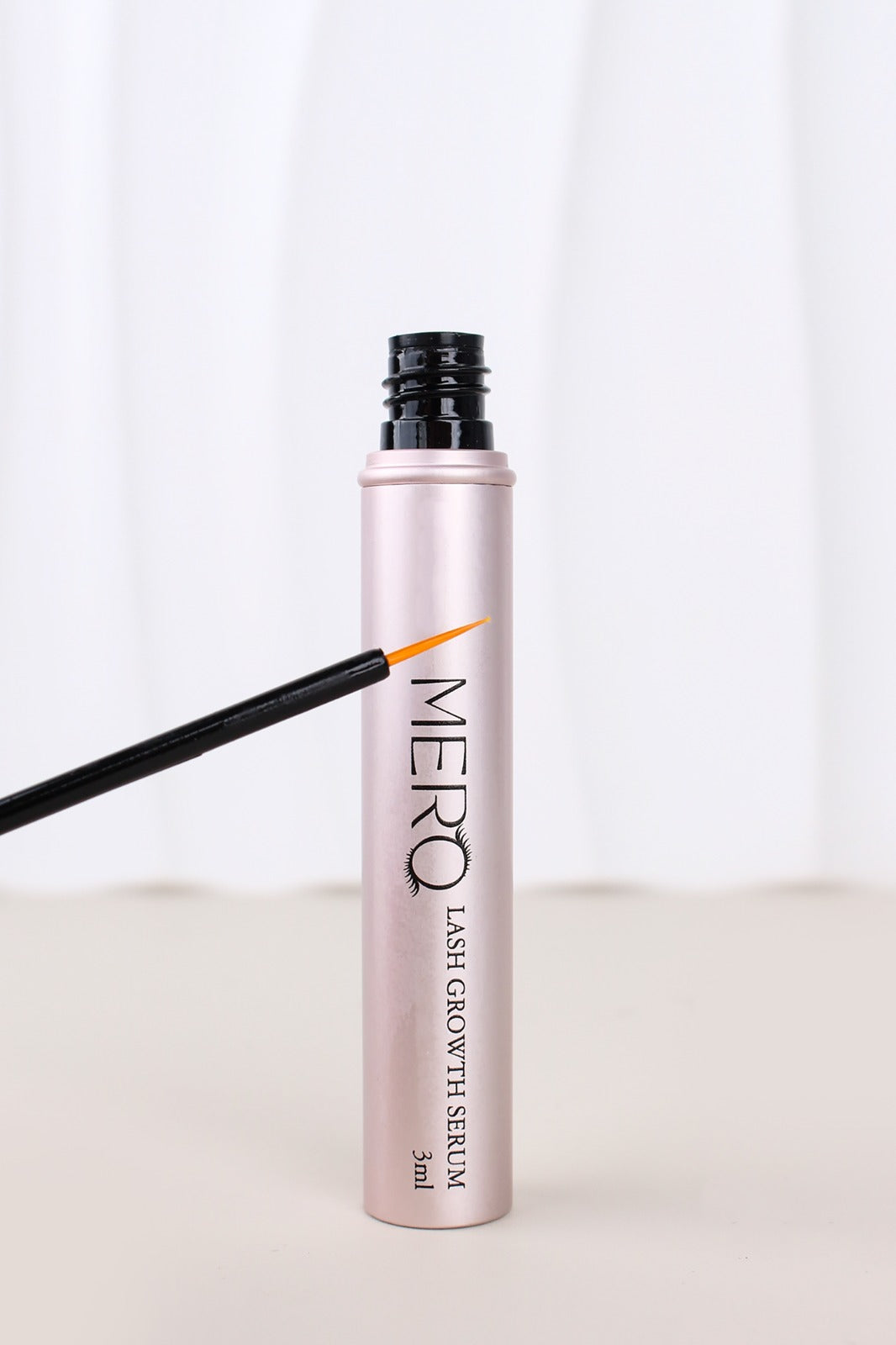 MERO Lash Growth Serum in a sleek pink tube with applicator, designed for nourishing and enhancing lashes.
