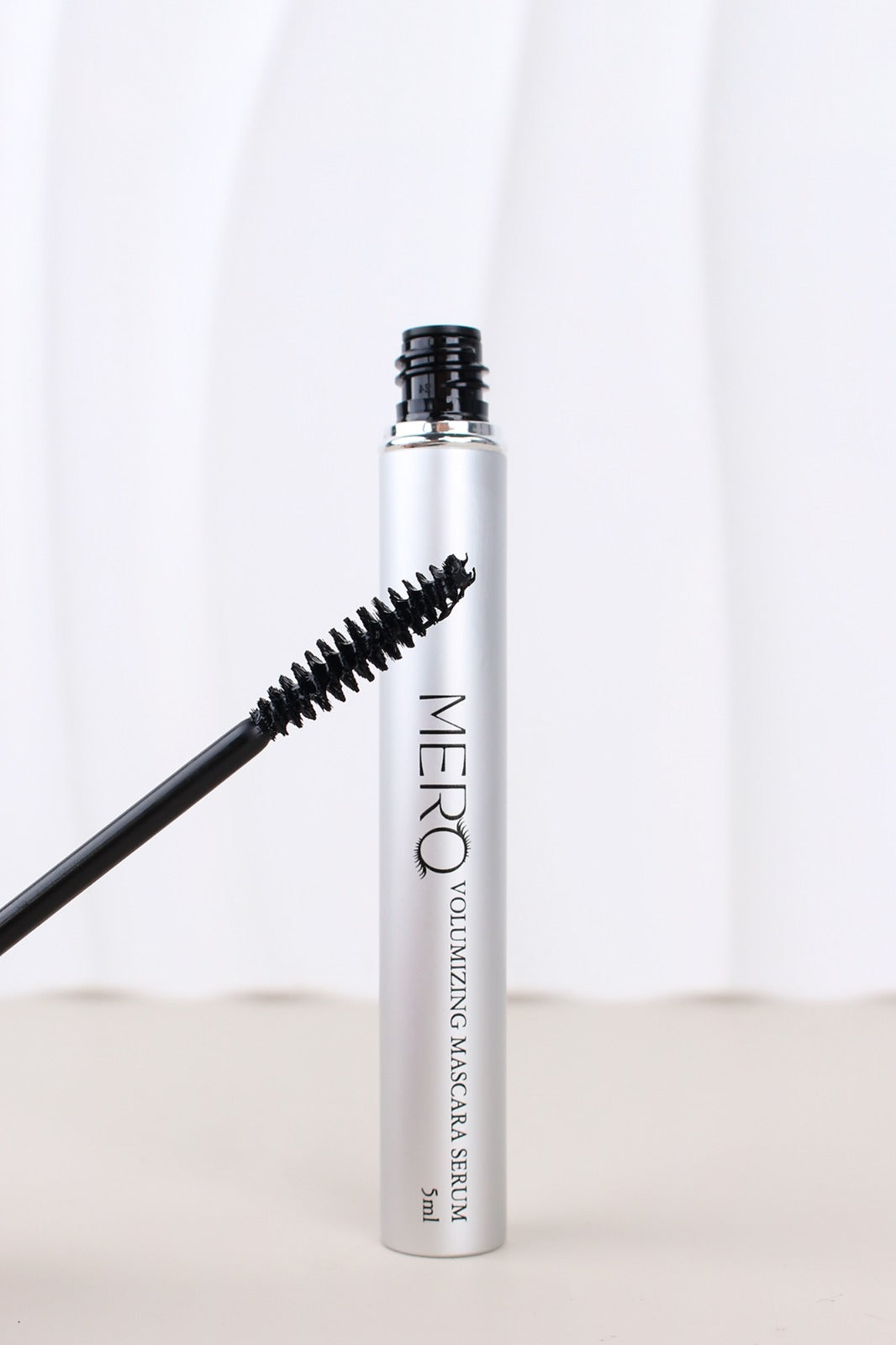 Mero volumizing mascara serum with applicator brush for enhancing lash length and volume.